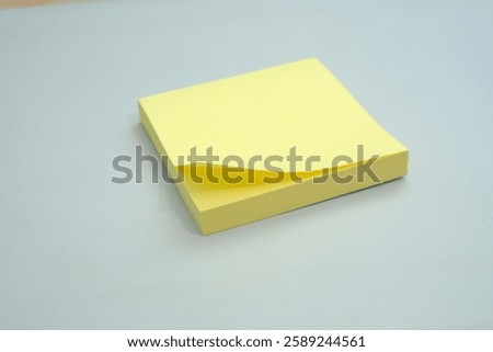 Stack of yellow sticky notes surrounded by several crumpled pieces of paper on a clean, light surface, representing brainstorming, creativity, problem-solving, and the process of working through ideas