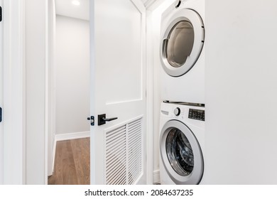 Stackable White Front Load Washer And Dryer In White Closet