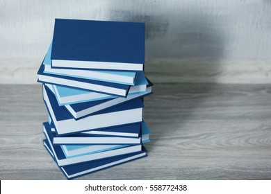 Stacked books on gray wooden floor in room - Powered by Shutterstock