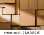 Stacked cardboard boxes arranged in a neat pattern under natural light