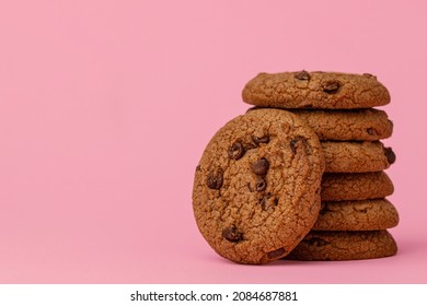 Stacked Chocolate Chip Cookies Against Pink Background