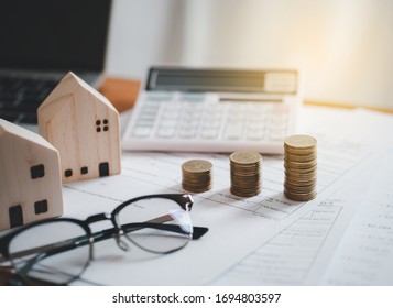Stacked of Coins with calculator,House model,tax form,glasses and tablet,Income Tax Raise Concept. - Shutterstock ID 1694803597