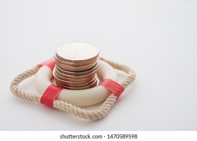 Stacked coins in red lifebuoy or lifebelt with white background copy space. Assets wealth, money saving or money investment protection and security by insurance concept. Risk management analysis.