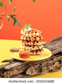 Stacked Croissant Waffle in Yellow Table and Orange Background. Croffle is Viral Cake from South Korea. Concept Pop Color Food, Copy Space for Text