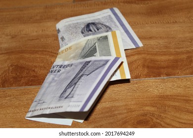 stacked danish banknotes on the wooden surface - Shutterstock ID 2017694249