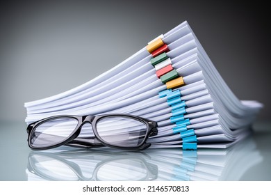 Stacked Documents With Colorful Paperclips And Eyeglasses