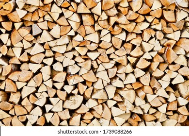 Stacked firewood close-up. Firewood storage close up. Stocks of wooden logs close-up. Chopping wood. Logging in the village. Rustic lifestyle. Woodpile with firewood full frame image. Wooden texture.