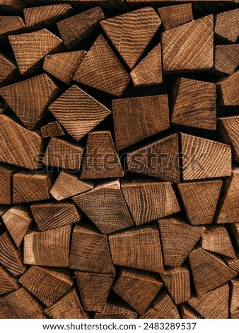 Stacked firewood of different shapes from forest trees for sale