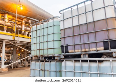 Stacked intermediate bulk containers store liquids at industrial facility, transportation readiness.