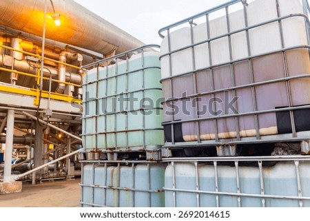 Stacked intermediate bulk containers store liquids at industrial facility, transportation readiness.