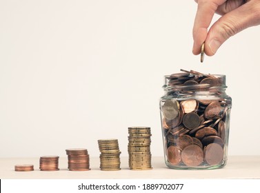 Stacked money coins in the form of a staircase to a jar filled with money coins, hand of a man puts a money coin in the jar, Concept for pension, reserve, savings or as a pension provision - Shutterstock ID 1889702077