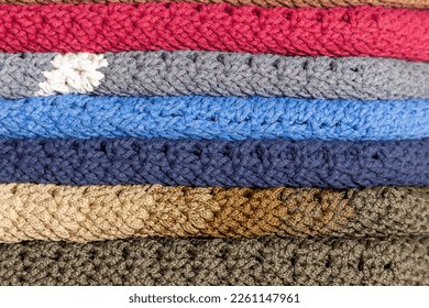 Stacked multi  colored crocheted garment items 
