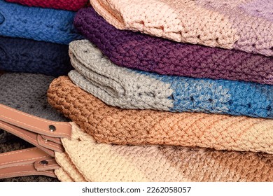 Stacked multi  colored crocheted garment items 