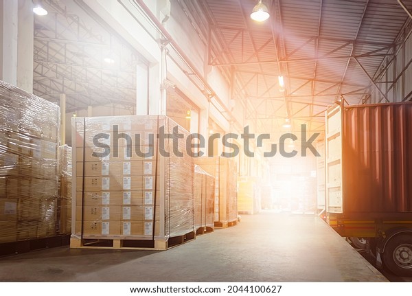 Stacked of Package Boxes on Pallets\
Loading with Shipping Cargo Container. Truck Parked Loading at Dock\
Warehouse. Delivery. Supply Chain. Warehouse Logistics. Cargo\
Freight Truck\
Transportation.	