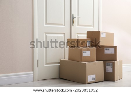 Stacked parcels near door on floor. Delivery service