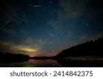 stacked photos showing the Perseid meteor shower against the August northern sky seen above the lake