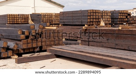 stacked piles of new railroad ties also called railway sleepers with anti-split plates on the ends
