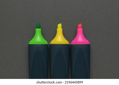 Stacked in a row of colored markers on a gray background. The minimum concept of business and education. Flat lay.