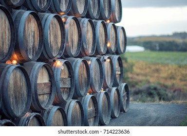 Stacked Rustic Oak Barrels Near A Vineyard In California Wine Country