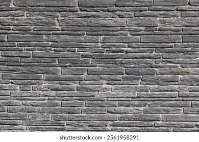 a Stacked stone brick wall. Stone cladding wall made of natural grey rocks