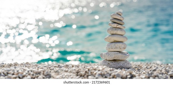 Stacked stones on a beautiful white pebble beach in the Mediterranean - Shutterstock ID 2172369601