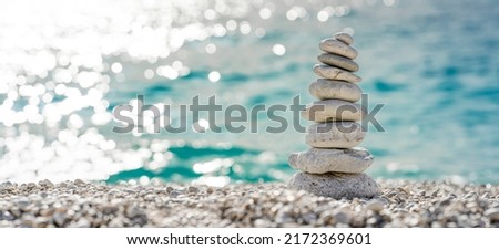 Stacked stones on a beautiful white pebble beach in the Mediterranean