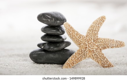 Stacked stones and starfish on sand in a Japanese ornamental or zen garden. - Powered by Shutterstock