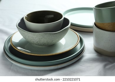 Stacked stylish empty dishware on table, closeup