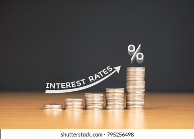 STACKED US QUARTER COINS ON WOODEN TABLE WITH WHITE ILLUSTRATION SHOWS INCREASING OF INTEREST RATES / FINANCIAL CONCEPT  - Shutterstock ID 795256498