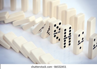 Stacked White Dominoes Falling Over.