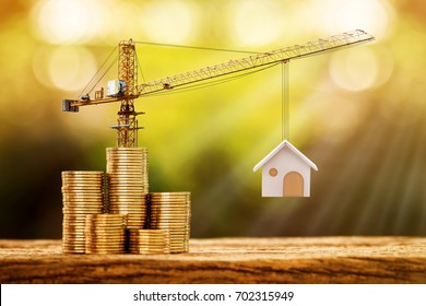 Stacking Gold Coins With Increase And Tower Crane And Hoist Brake Solutions With Build New House In The Public Park, Saving Money And Loan For Construction Real Estate And Home Concept.