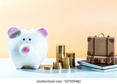 The Stacking Gold Coins And Luggage Model And Passport And Piggy Bank On Brown Background, Saving Money For Travel Planning Concept.