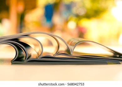 stacking of opened magazine with blurred background 