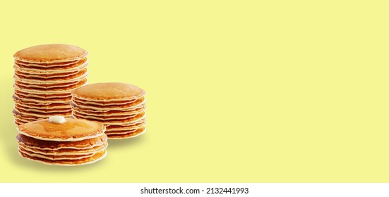 Stacks of American pancakes on a yellow background. Copy space. The concept of Pancake Day, Maslenitsa, pancake festival.