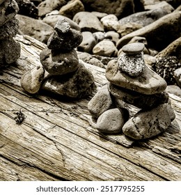 Stacks of balanced rocks on driftwood by a riverbed, capturing nature’s art and tranquility. Perfect for zen, meditation, and outdoor themes. - Powered by Shutterstock