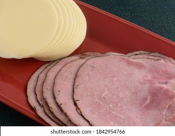 Stacks Of Black Forest Ham And Provolone Cheese Cold Cut Slices On Red Platter