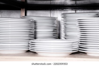 Stacks Of Clean White Plates On Shelf. Close Up