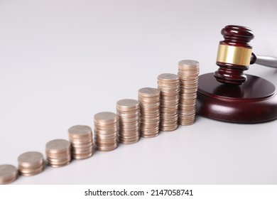 Stacks of coins and court gavel financial crimes. Money pyramids and bankruptcy concept