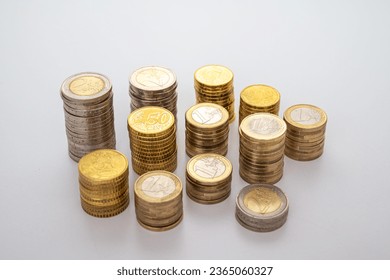 Stacks of coins next to each other, on white surface. Quantity of money, currency and wealth. - Shutterstock ID 2365060327