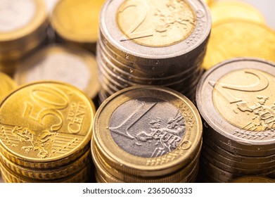 Stacks of coins next to each other, on white surface. Quantity of money, currency and wealth. - Shutterstock ID 2365060333