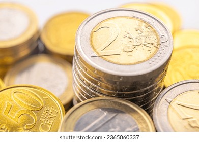 Stacks of coins next to each other, on white surface. Quantity of money, currency and wealth. - Shutterstock ID 2365060337