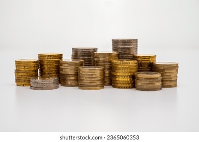 Stacks of coins next to each other, on white surface. Quantity of money, currency and wealth. - Shutterstock ID 2365060353