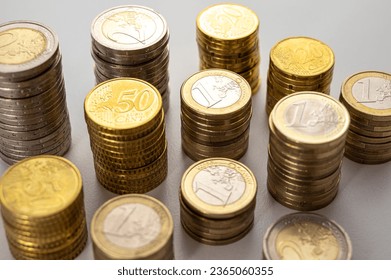 Stacks of coins next to each other, on white surface. Quantity of money, currency and wealth. - Shutterstock ID 2365060355