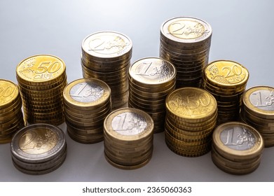 Stacks of coins next to each other, on white surface. Quantity of money, currency and wealth. - Shutterstock ID 2365060363