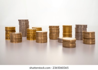 Stacks of coins next to each other, on white surface. Quantity of money, currency and wealth. - Shutterstock ID 2365060365