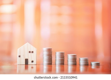 Stacks Of Coins On Desk With Mockup Wooden Houses; Investments; Business Growth; Saving Money; Transactions; Taxes; Building A House; Borrowing Money; Bank Deposits; Financial Management; Target.
