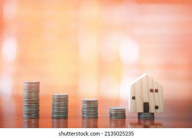 Stacks Of Coins On Desk With Mockup Wooden Houses; Investments; Business Growth; Saving Money; Transactions; Taxes; Building A House; Borrowing Money; Bank Deposits; Financial Management; Target.
