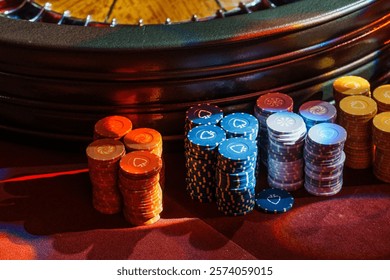 Stacks of colorful poker chips under ambient lighting create an atmosphere of anticipation and luck at the casino table.