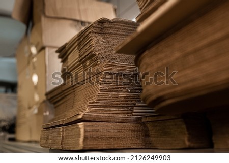 stacks of containerboard sheets in warehouse facility