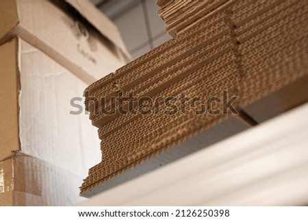 stacks of containerboard sheets in warehouse facility